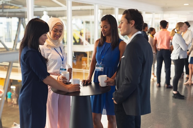 Photo business people interacting with each other while having coffee in office