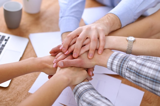 Business people joining hands over table. Start up team