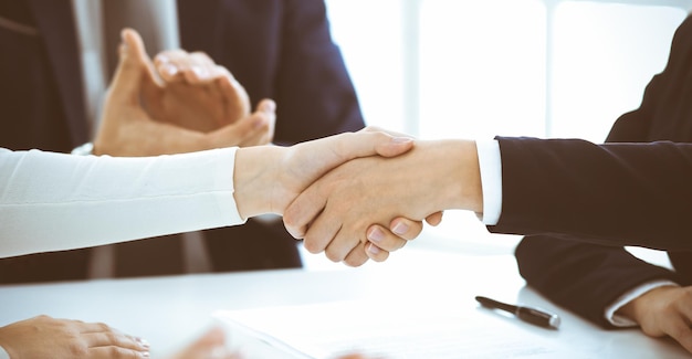 Foto uomini d'affari o avvocati che stringono la mano finendo una riunione close-up concetti di negoziazione e stretta di mano