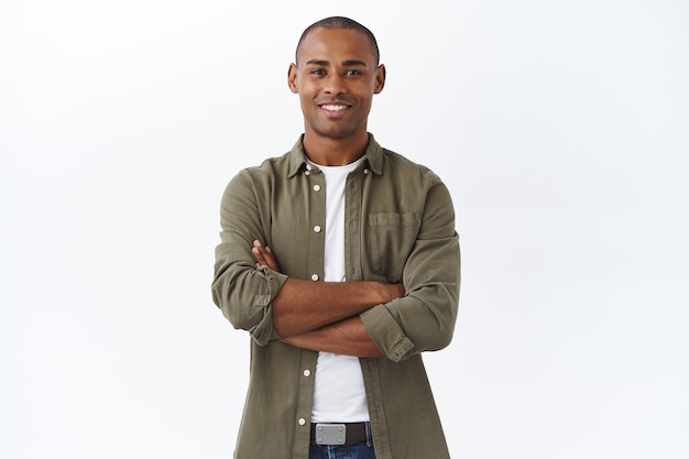 Photo business, people and lifestyle concept. portrait of handsome african american man cross hands on chest and smiling pleased