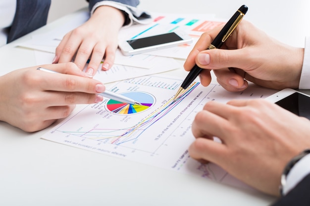 Business people making report at table with charts isolated on white