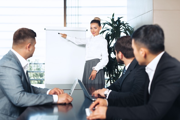 Business people meeting around a boardroom table discussing strategy