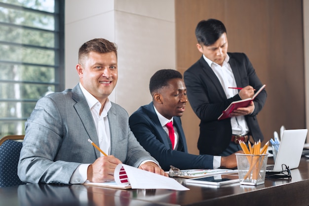 Business people meeting around a boardroom table discussing strategy