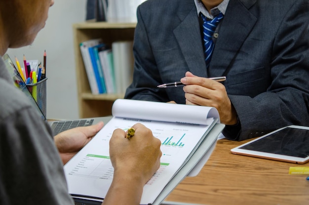 Business people meeting at the office by analyzing data from financial graphs and investment charts to plan a marketing team