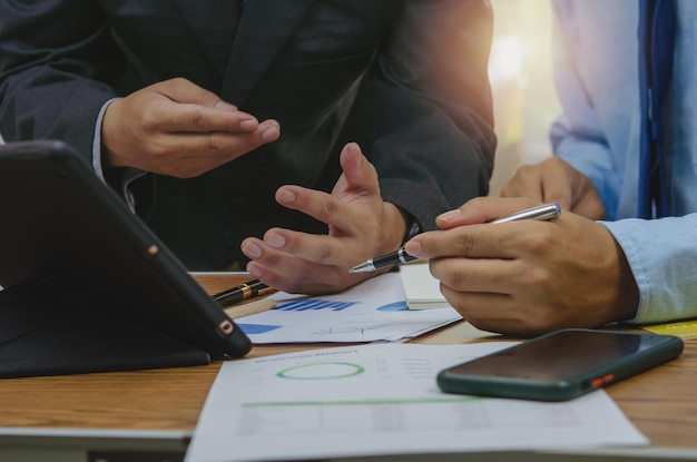 Business people meeting at the office by analyzing data from financial graphs and investment charts to plan a marketing team