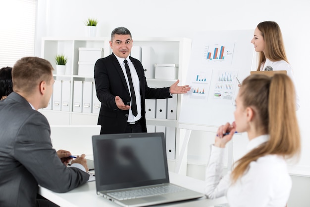 Business people meeting in office to discuss project. Adult businessman pointing to diagram. Business success and teamwork concept