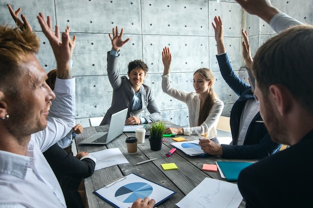 Деловые люди на встрече, поднимая руки, концепция команды успеха корпоративного сотрудничества, люди, работающие с отчетами о финансовых данных