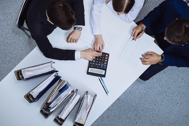 Business people at meeting, view from above. Bookkeeper or financial inspector making report, calculating or checking balance. Internal Revenue Service checking financial document. Audit and tax conce