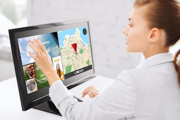 Photo business, people, navigation and technology concept - woman with gps navigator map on computer touchscreen in office