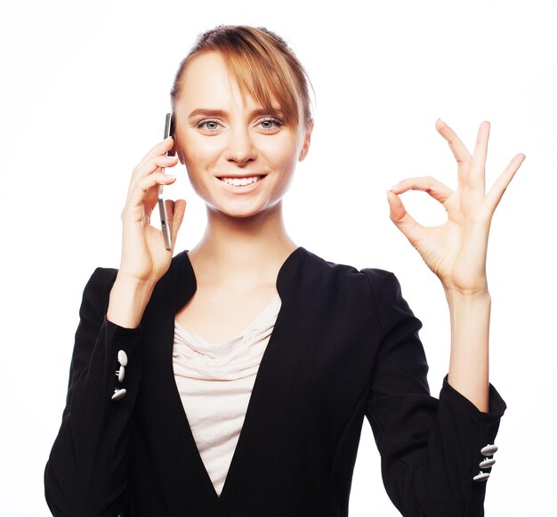 Business, people and office concept: young business woman with mobile phone. Positive emotion.Isolated on white.