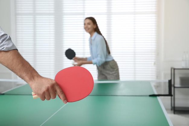 Business people playing ping pong in office focus on tennis racket