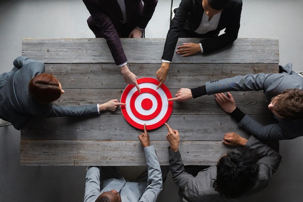 Business people pointing at red target