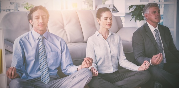 Foto uomini d'affari che praticano yoga in ufficio