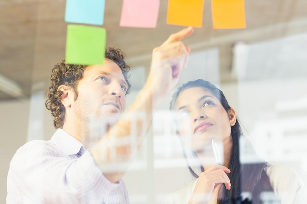 Business people reading adhesive notes