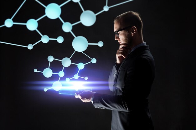 business, people, science, biology and future technology concept - close up of businessman with transparent tablet pc computer and virtual molecule over black background