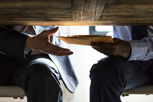 Photo business people sending documents under the table