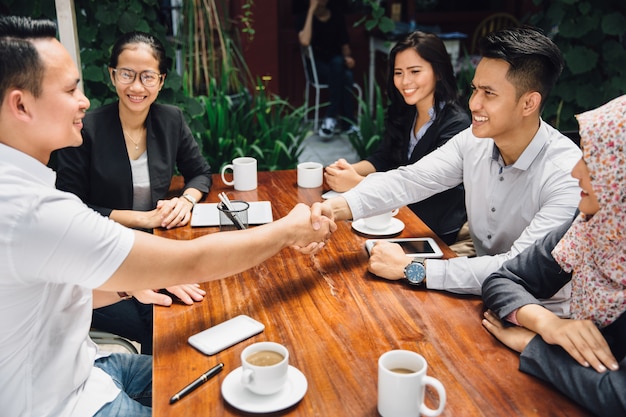 Business people shaking hands at cafe