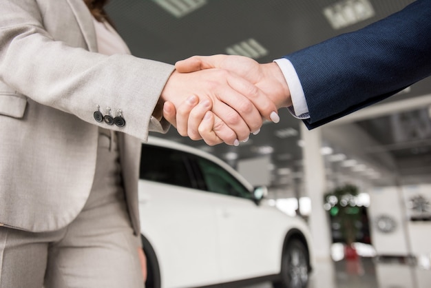 Photo business people shaking hands close up