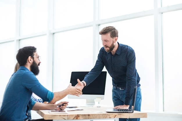 Business people shaking hands over the desk