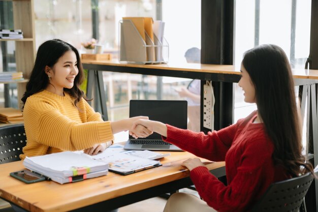 Photo business people shaking hands during a meeting in modern office