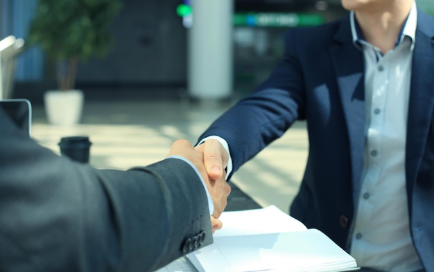 Foto gli uomini d'affari si stringono la mano, finendo una riunione.