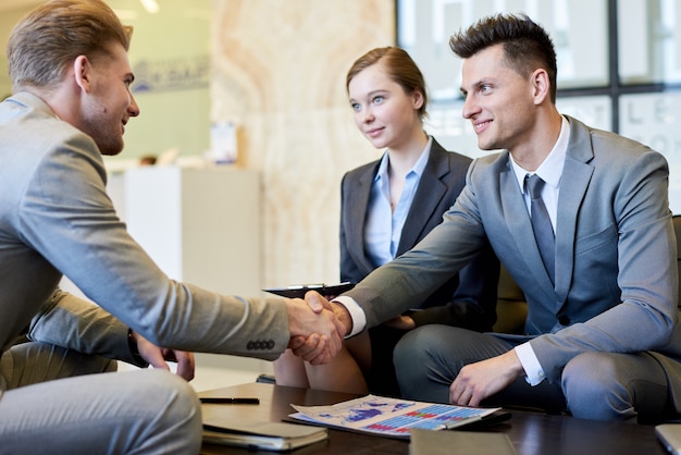 Business People Shaking Hands at Meeting Table