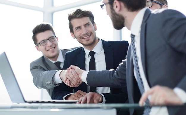 Business people shaking hands sitting at the office tablephoto with copy space