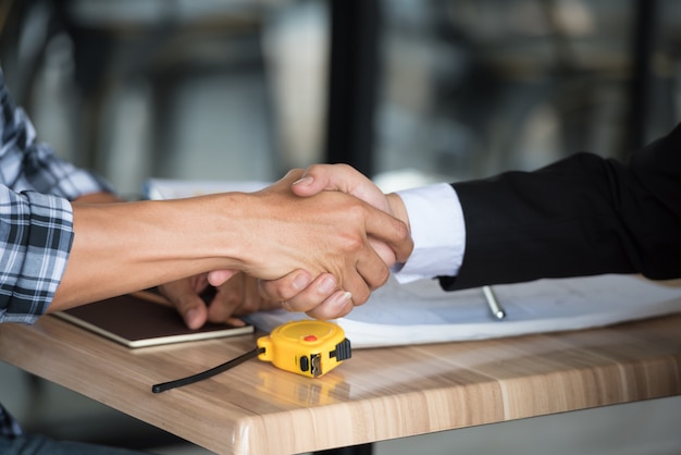 Photo business people shaking hands together in the meeting at site building.