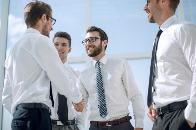 Business people shaking hands while standing in the office concept of partnership