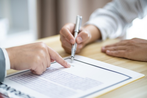 Деловые люди подписывают контракт на заключение сделки с агентом по недвижимости