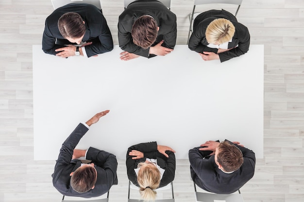 Business people sitting around empty table