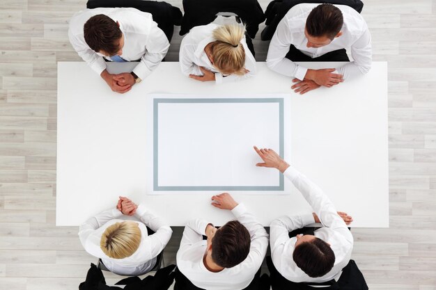 Business people sitting around empty table