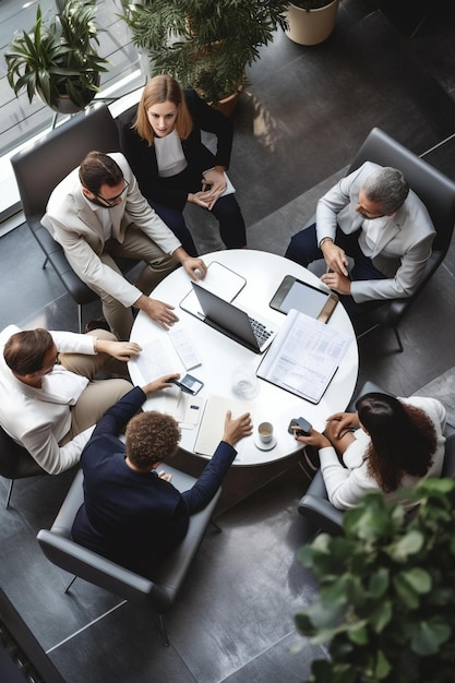 business people sitting around a round table with laptops and papers on it