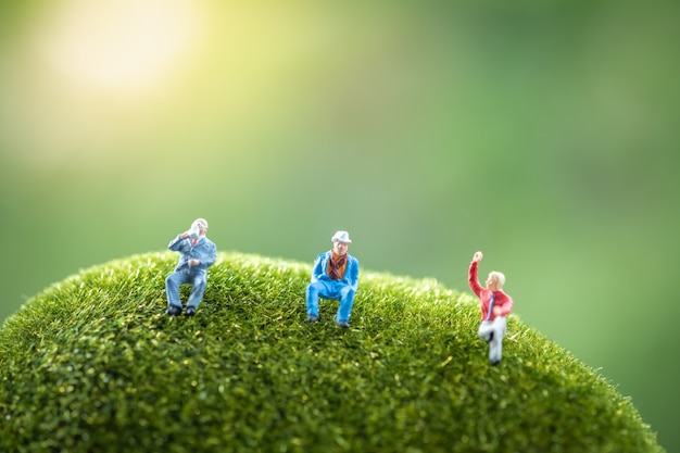 business people sitting on a green moss stone.