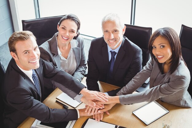 business people stacking hands in conference room