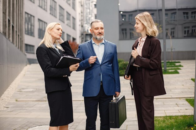 Business people standing and talk to each other in front of modern office