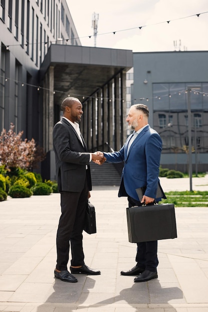 Business people standing and talk to each other in front of modern office