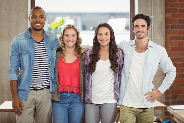 Business people standing with arms around creative office