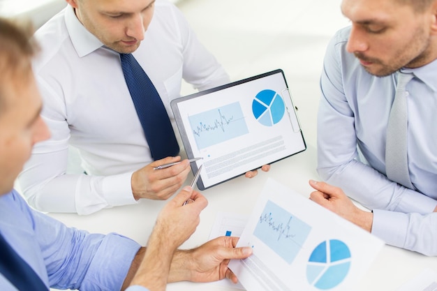 business, people, statistics and teamwork concept - close up of businessman hands with clipboard pointing pen to chart at office