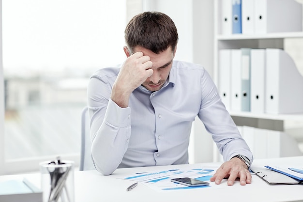 business, people, stress, deadline and technology concept - close up of businessman with smartphone