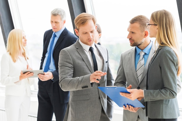 Business people talking at meeting in office near window