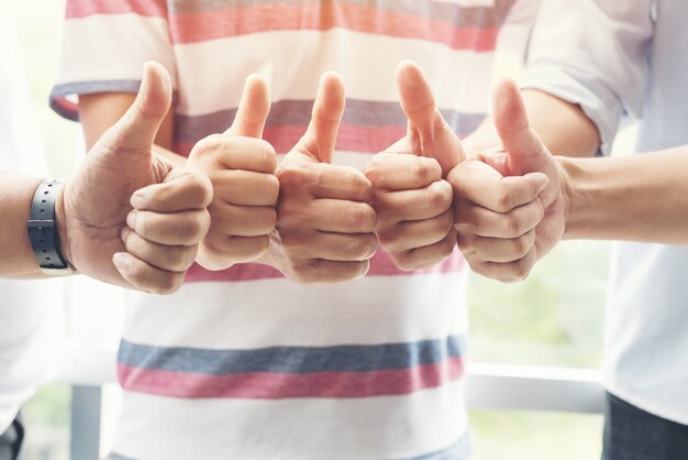 Photo business people team show thump up together for agreement sign