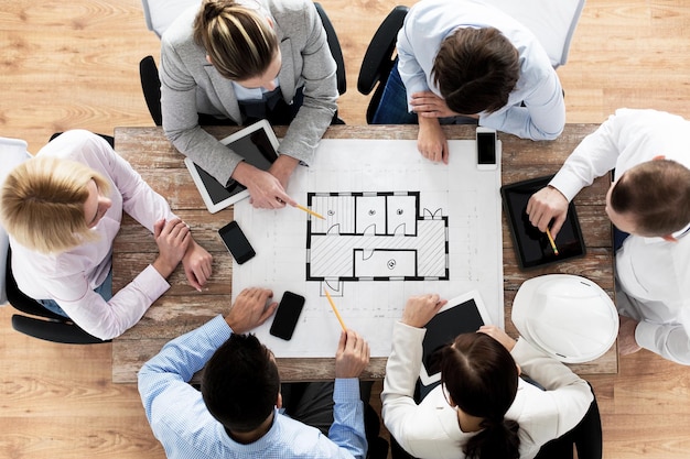 business, people and team work concept - close up of creative team sitting at table in office