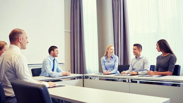 business, people and teamwork concept - group of smiling businesspeople meeting in office