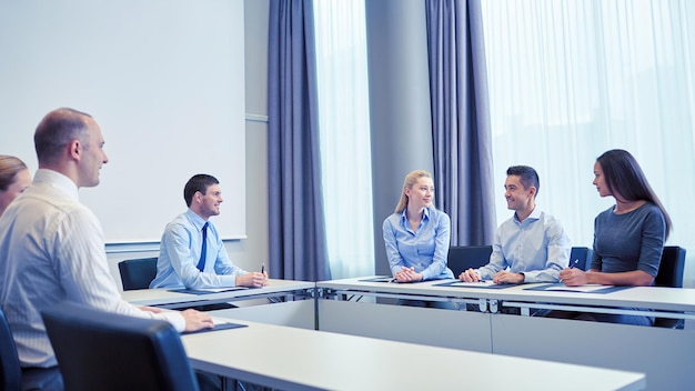 business, people and teamwork concept - group of smiling businesspeople meeting in office