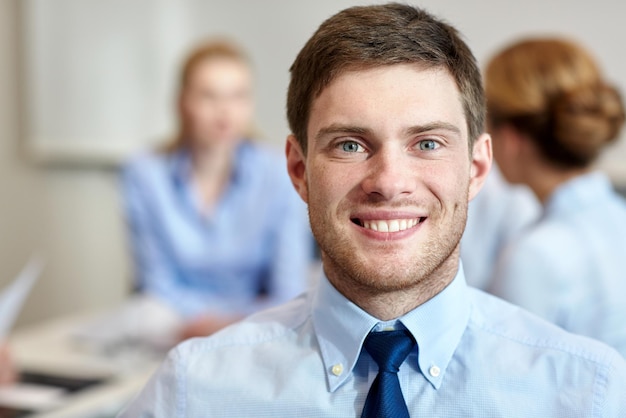 business, people and teamwork concept - smiling businessman with group of businesspeople meeting in office