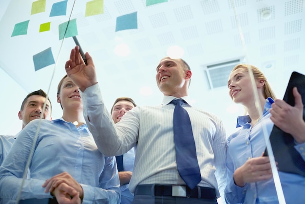 business, people, teamwork and planning concept - smiling business team with marker and stickers working in office