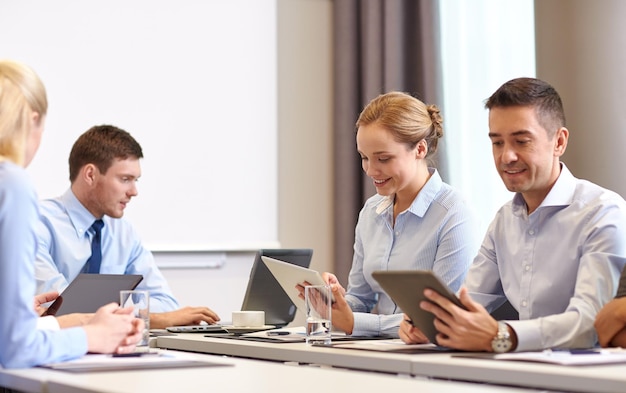 비즈니스, 사람 및 기술 개념 - 사무실에서 태블릿 PC 컴퓨터 회의와 함께 웃는 비즈니스 팀