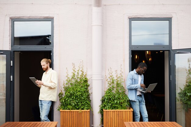 Business people using gadgets outdoors