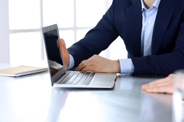 Business people using laptop computer while working together at the desk in modern office